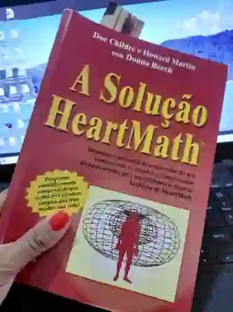Livro A Solução HeartMath segurado por uma mão